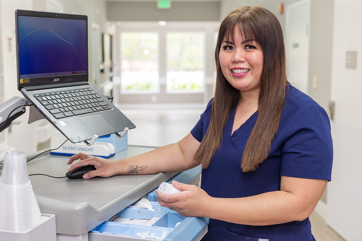 smiling nurse at a computer
