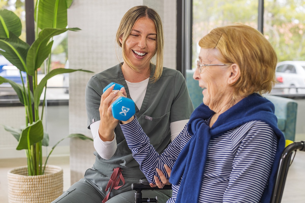 rehab nurse assisting elderly resident left weights